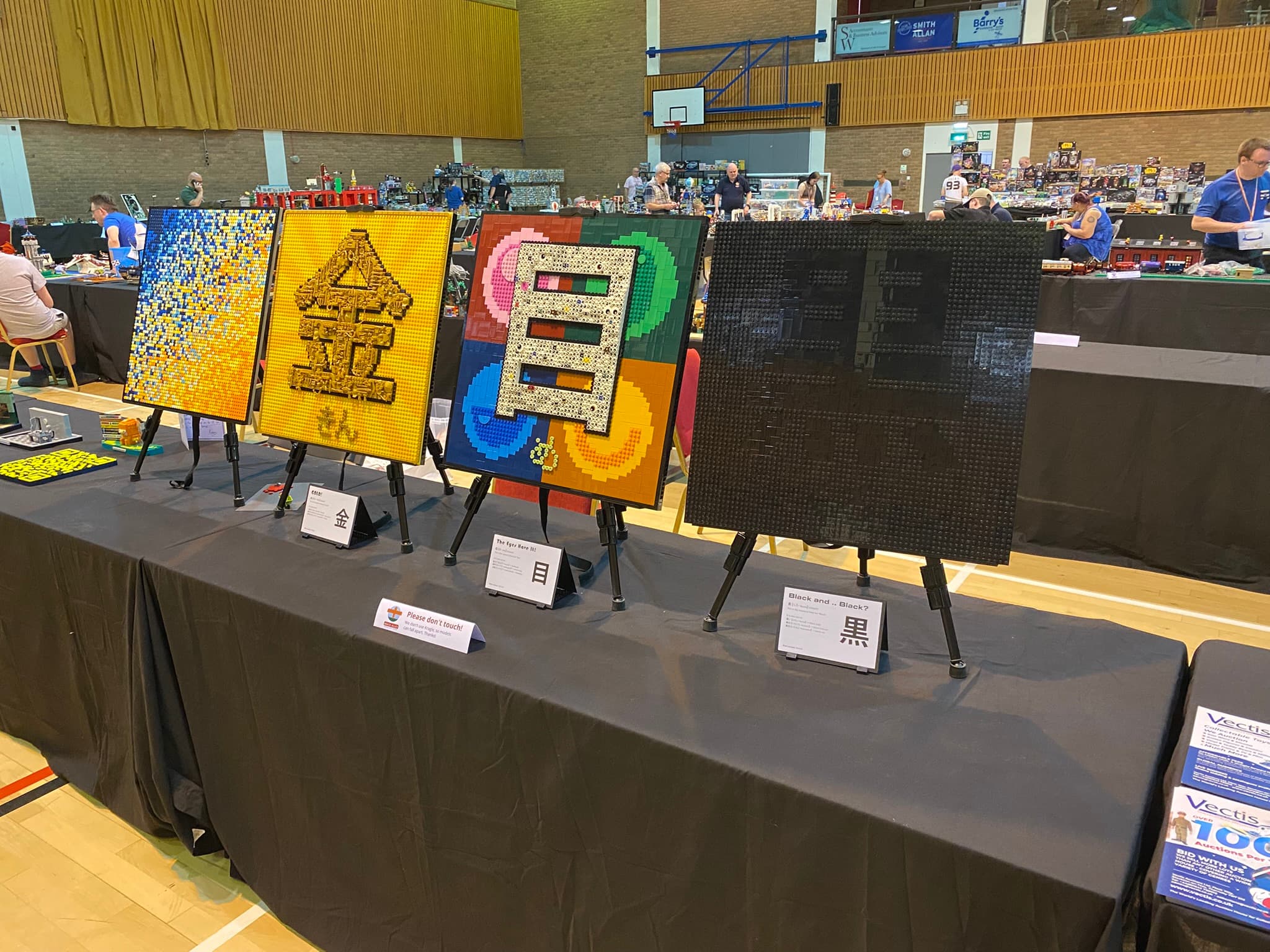 One of Clockson's tables at Darlington Brick Show 2025, on it you can see, Staring in to the Abyss, Gold!, The Eyes Have It, and Black and ... Black?