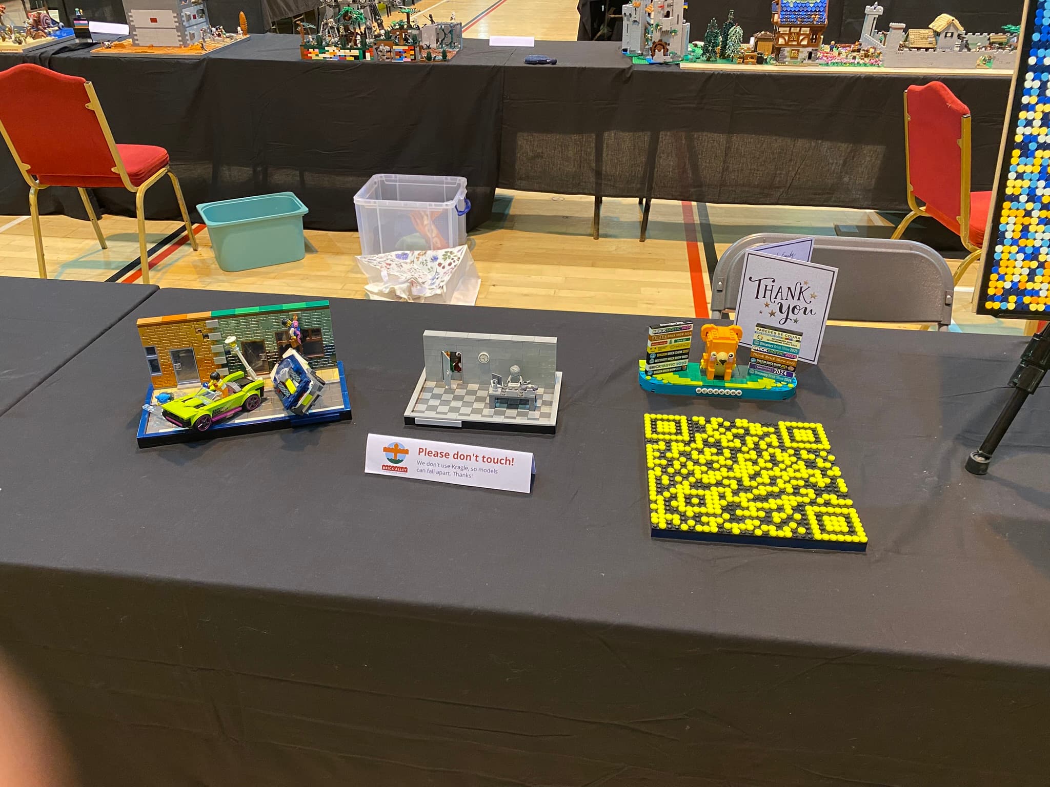 The second of Clockson's tables at Darlington Brick Show 2025, on it you can see The Weekend Cupboard, Cat in Road, Darlo Brickstack, and a brick built QR code.